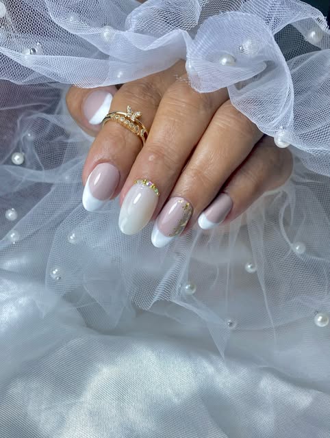 Nail art elegante en tonos blancos con detalle dorado